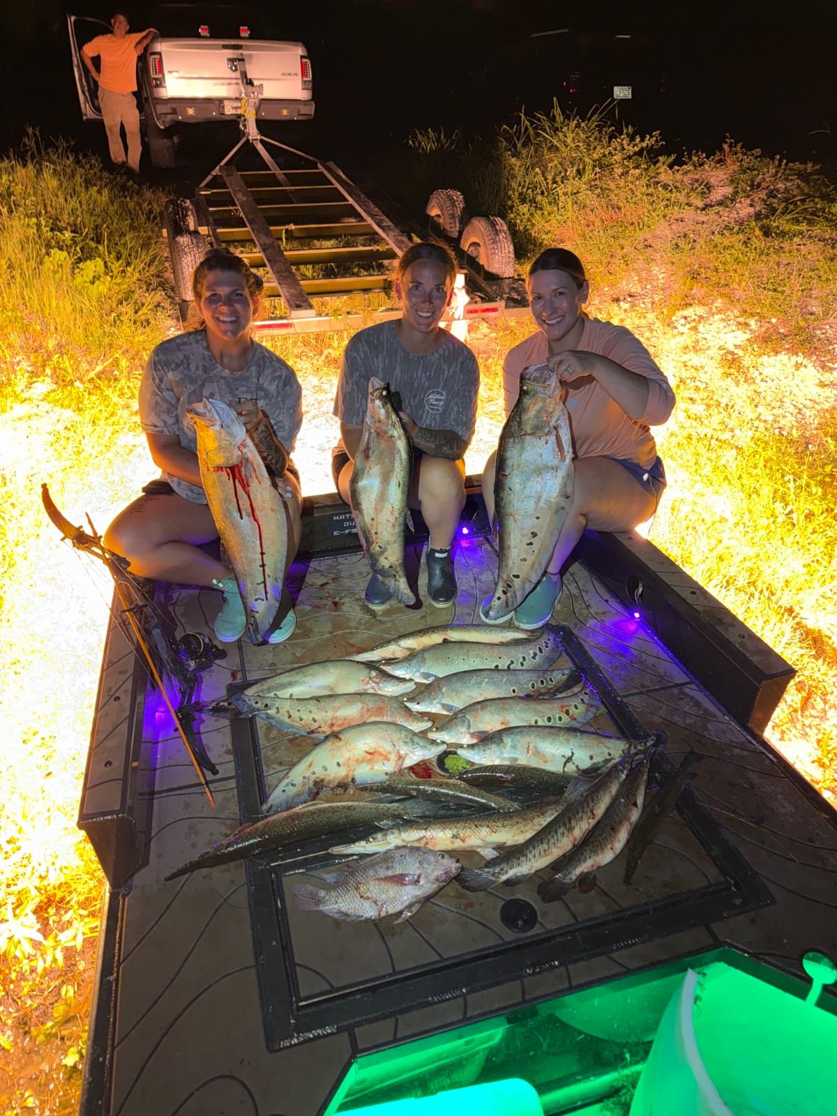 Three women holding clown knife fish after a Native Roots night trip