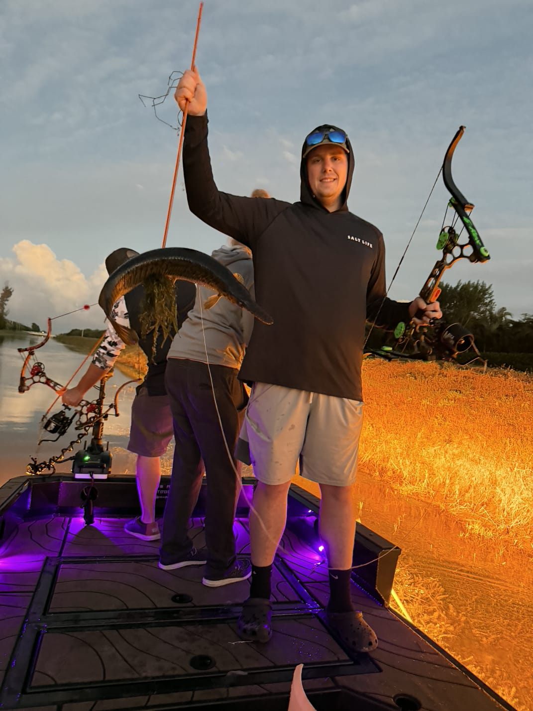 Native Roots Outdoor bowfishing trip photo with guests, fish, boat lights, and South Florida water