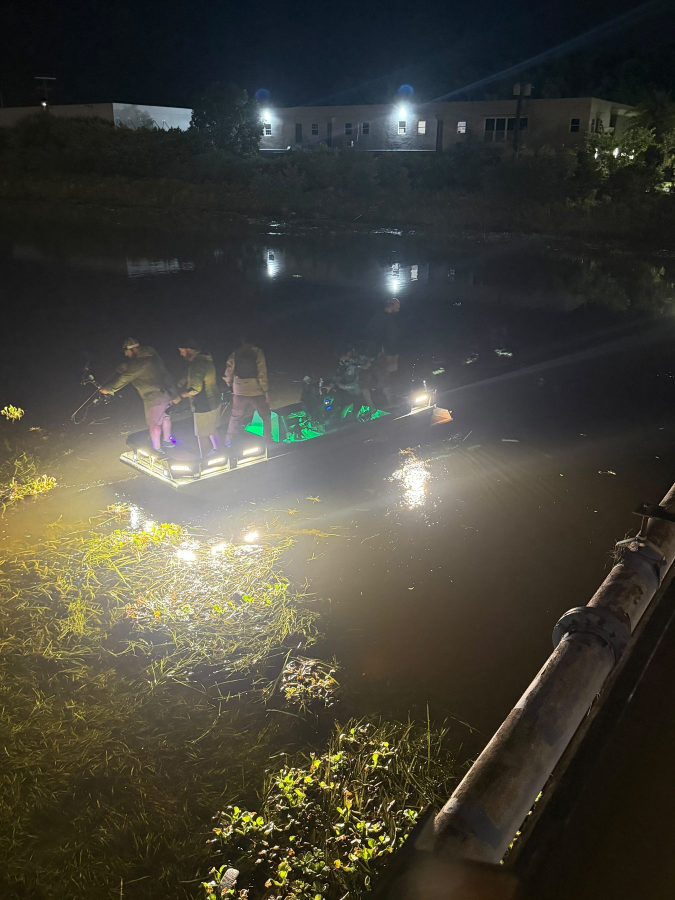 Native Roots bowfishing boat lit up on shallow South Florida water at night