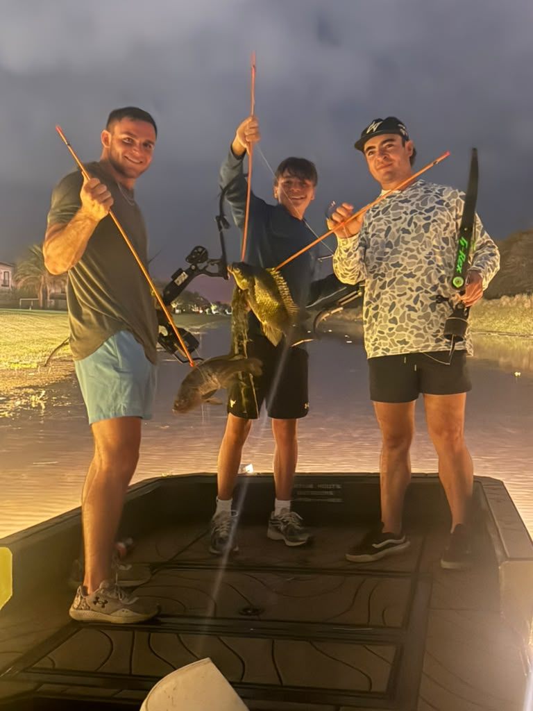 Native Roots Outdoor bowfishing trip photo with guests, fish, boat lights, and South Florida water