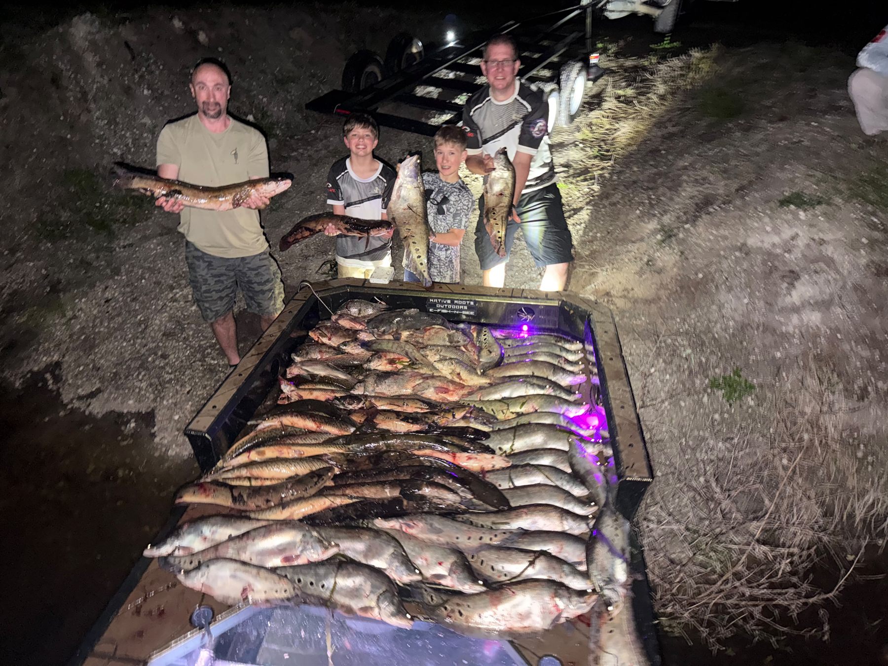 Large Native Roots bowfishing catch laid across the boat deck