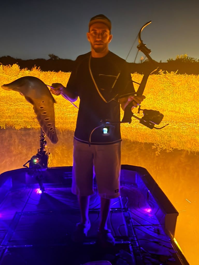 Native Roots Outdoor bowfishing trip photo with guests, fish, boat lights, and South Florida water
