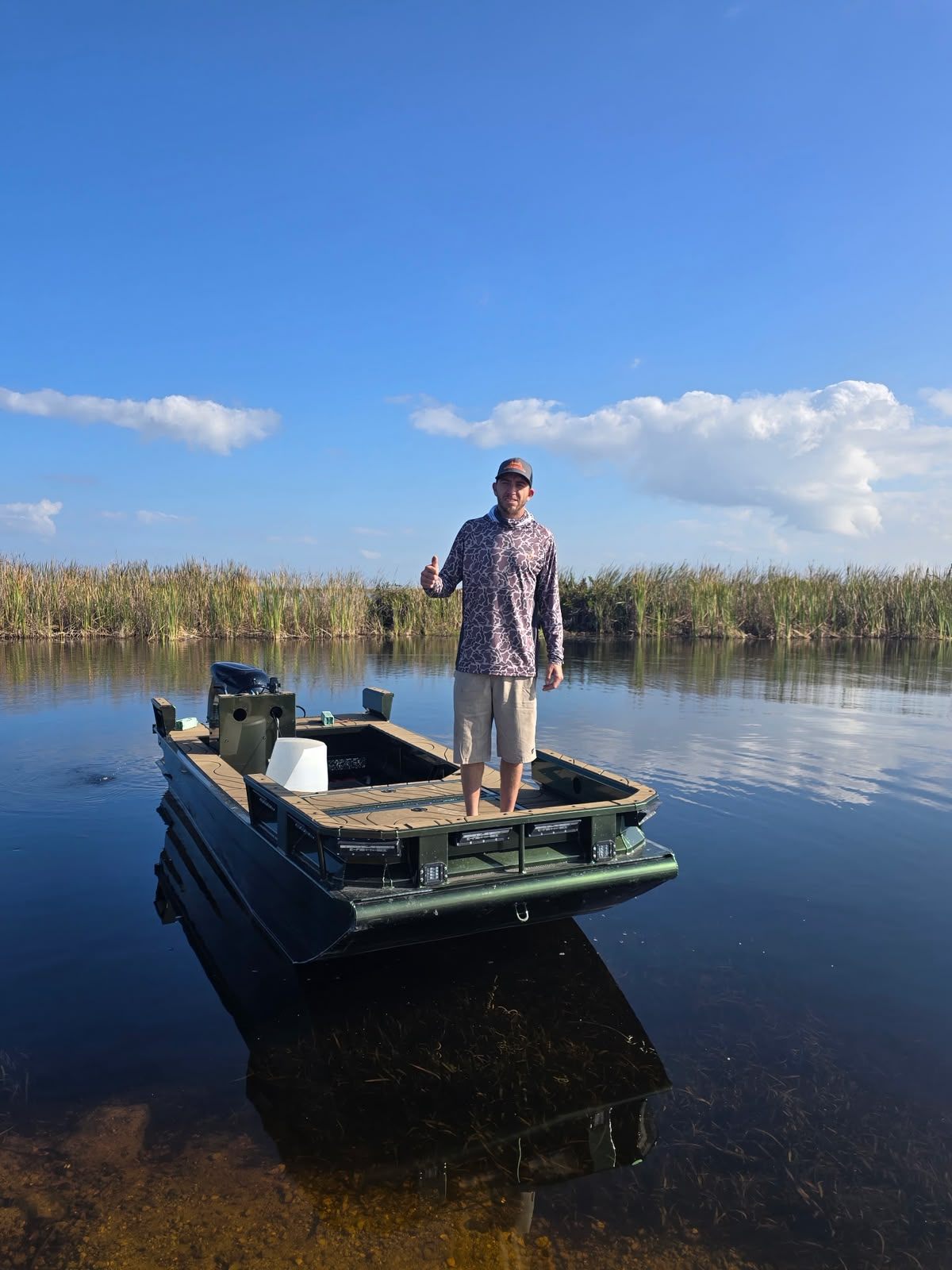 Native Roots shallow-water boat sitting on calm South Florida water during the day