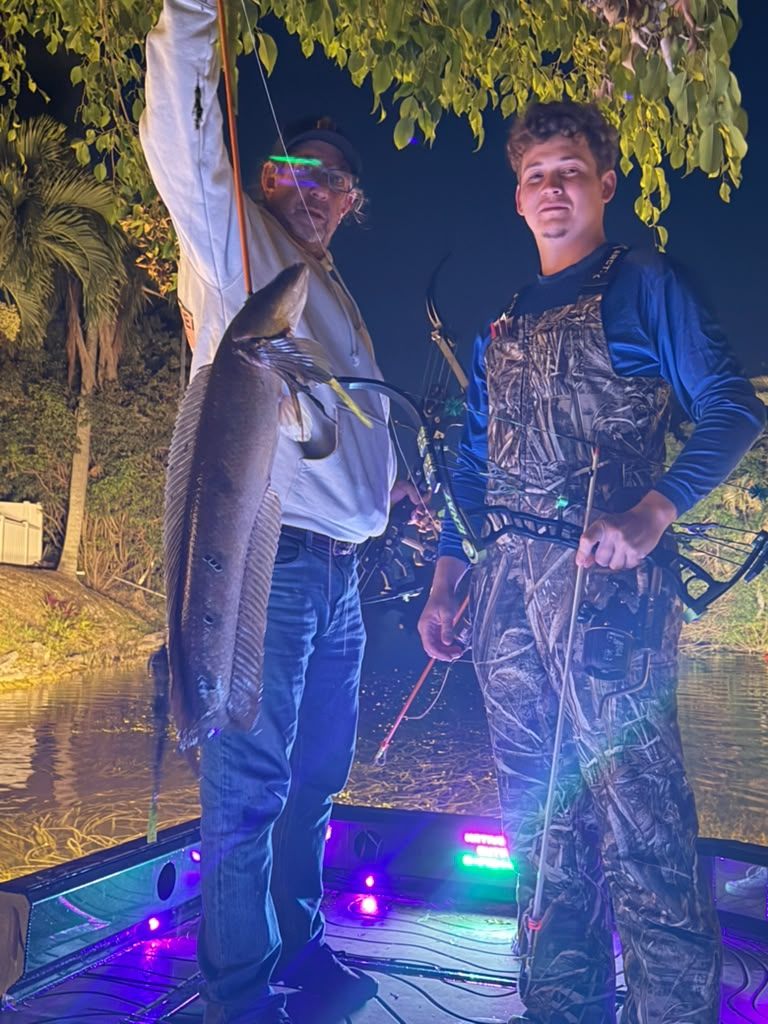 Native Roots Outdoor bowfishing trip photo with guests, fish, boat lights, and South Florida water