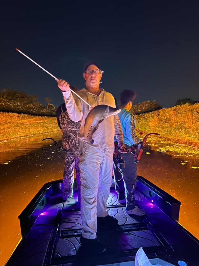 Native Roots Outdoor bowfishing trip photo with guests, fish, boat lights, and South Florida water